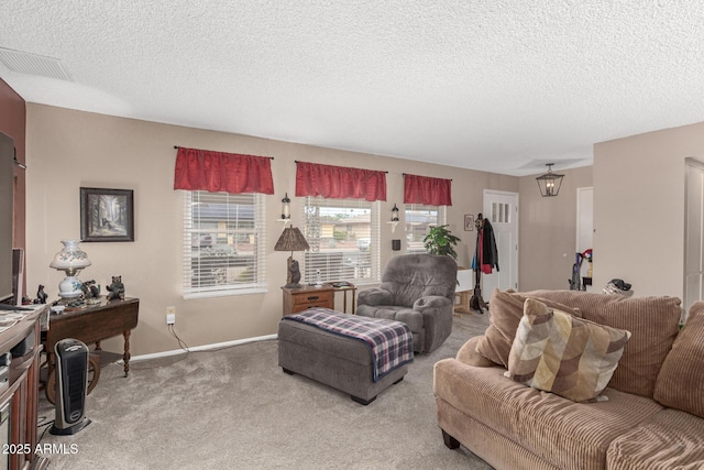 living area featuring baseboards, visible vents, carpet floors, and a textured ceiling