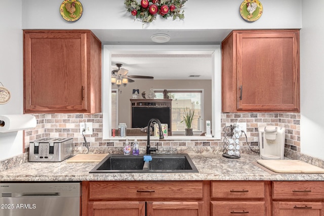 kitchen with stainless steel dishwasher, a ceiling fan, tasteful backsplash, and a sink