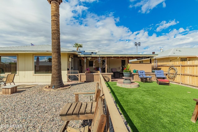 rear view of property featuring solar panels, a patio, a yard, and fence