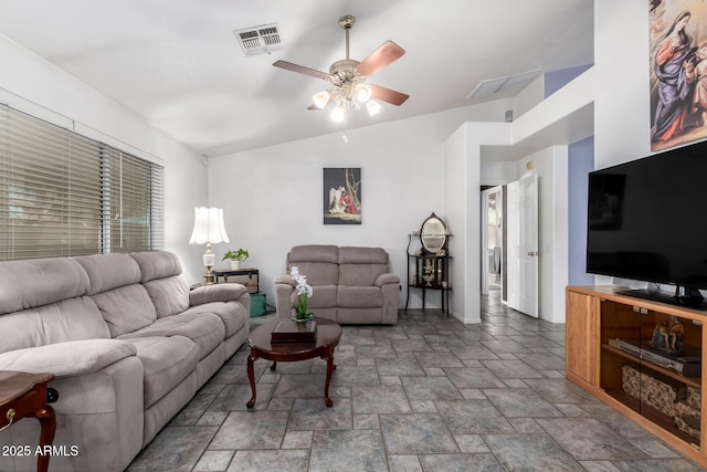 living area featuring ceiling fan, stone finish flooring, visible vents, and baseboards