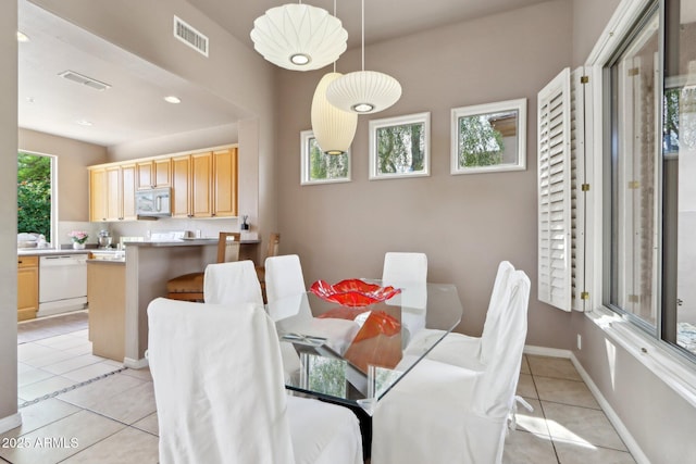 dining area with baseboards, visible vents, and light tile patterned floors