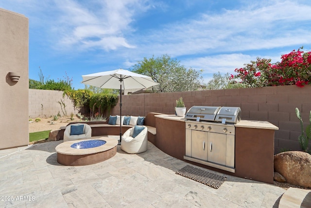 view of patio / terrace with a fenced backyard, area for grilling, and an outdoor fire pit