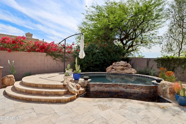 view of swimming pool featuring a fenced backyard, a patio area, and an in ground hot tub
