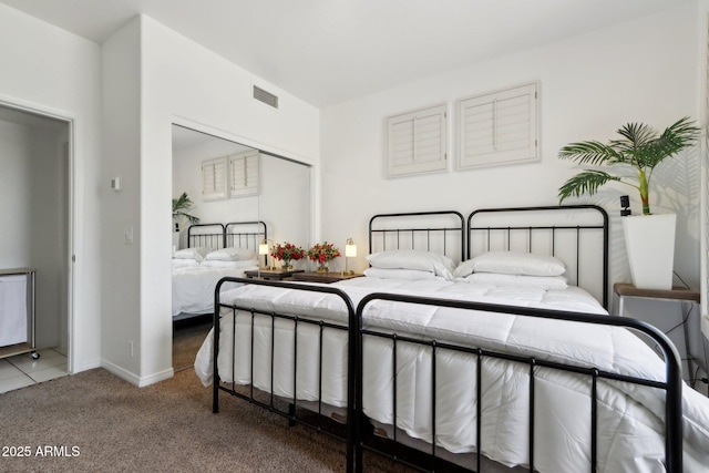 carpeted bedroom featuring a closet, visible vents, and baseboards
