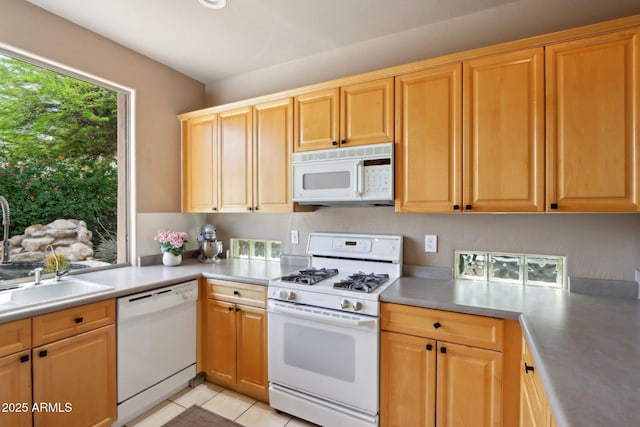 kitchen with light countertops, white appliances, a sink, and light tile patterned flooring