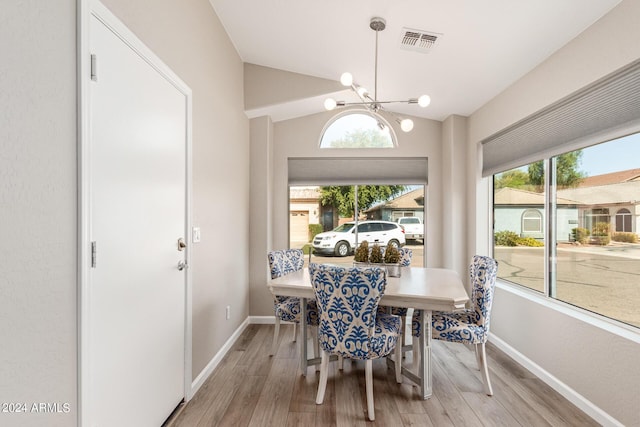 dining space with lofted ceiling, light wood-style flooring, visible vents, and baseboards