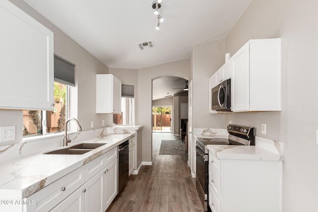 kitchen featuring visible vents, stainless steel appliances, a sink, and white cabinetry