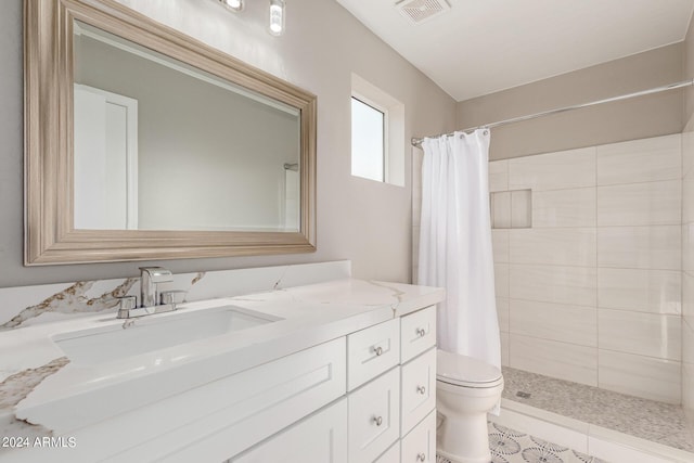 bathroom featuring toilet, vanity, visible vents, and a shower stall