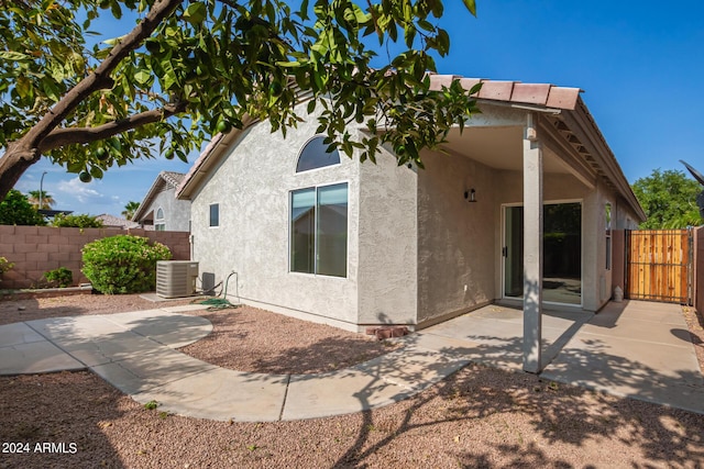 back of property featuring a fenced backyard, a patio area, cooling unit, and stucco siding