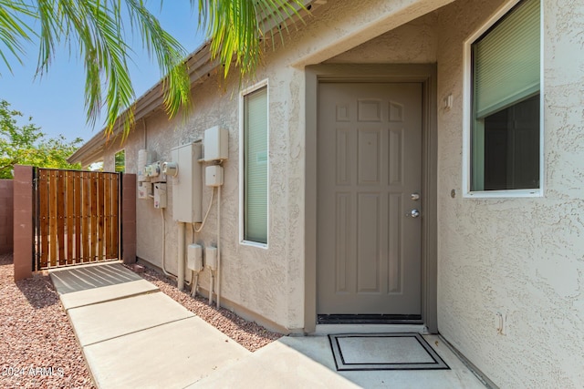 doorway to property with a gate and stucco siding