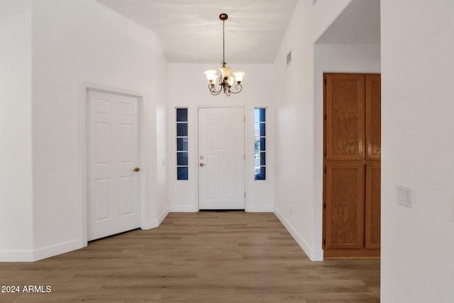 entrance foyer with an inviting chandelier and light hardwood / wood-style floors