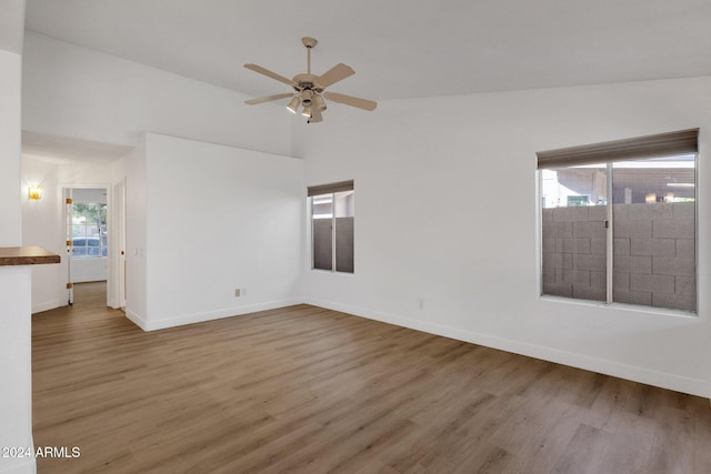 spare room with lofted ceiling, hardwood / wood-style flooring, and ceiling fan