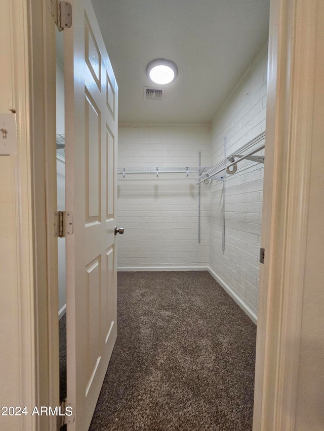 spacious closet featuring dark carpet