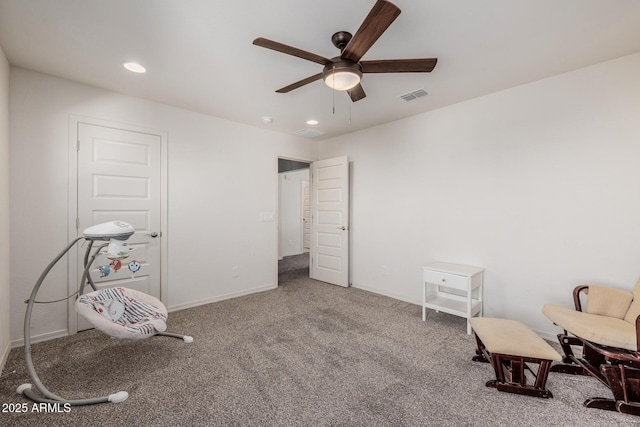 sitting room featuring ceiling fan and carpet