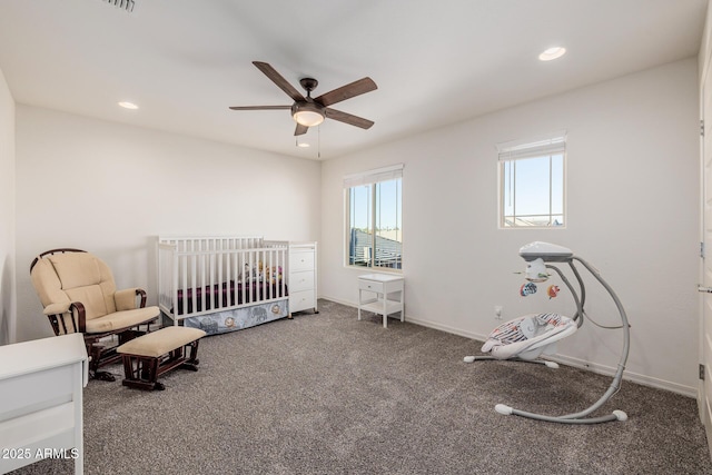 bedroom featuring ceiling fan and a nursery area