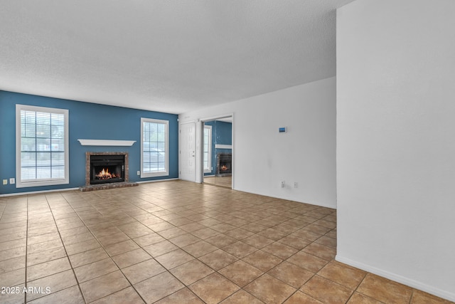 unfurnished living room featuring a healthy amount of sunlight, a brick fireplace, and light tile patterned floors