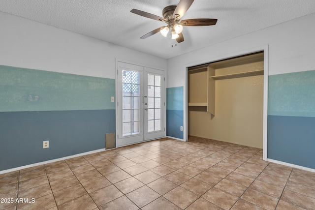 unfurnished bedroom featuring tile patterned floors, french doors, a textured ceiling, and a ceiling fan