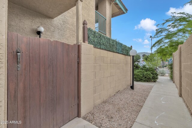 view of property exterior featuring stucco siding and fence