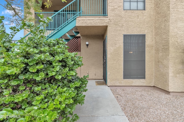 doorway to property with stucco siding and a balcony