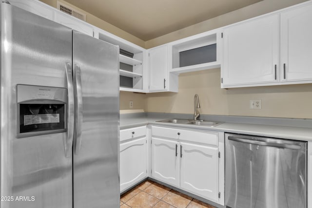 kitchen featuring open shelves, a sink, light countertops, appliances with stainless steel finishes, and visible vents