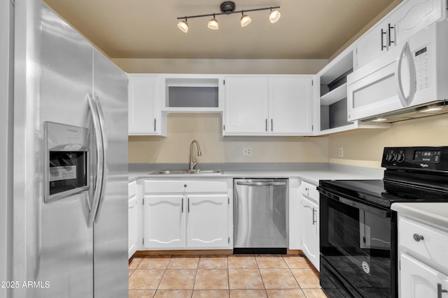kitchen featuring stainless steel appliances, a sink, open shelves, light countertops, and light tile patterned floors