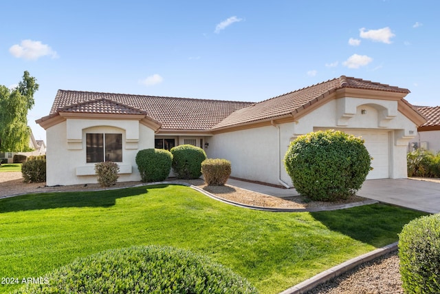 mediterranean / spanish-style home featuring a garage and a front lawn