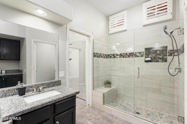 bathroom with vanity and a shower with door