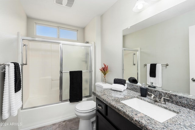 full bathroom featuring vanity, toilet, and enclosed tub / shower combo