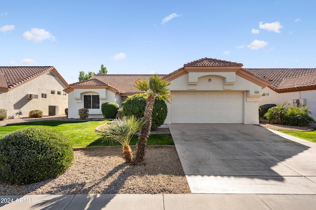 mediterranean / spanish house featuring a front yard and a garage