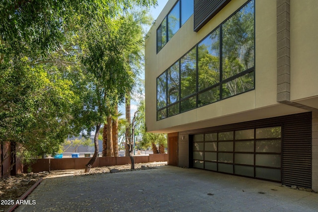 view of side of property featuring fence and a garage