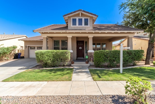 view of front of house with a porch, a garage, and a front lawn