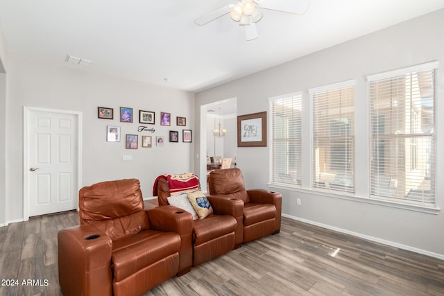 interior space with wood-type flooring and ceiling fan with notable chandelier