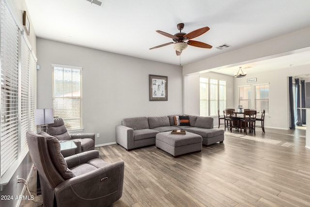 living room featuring hardwood / wood-style floors and ceiling fan with notable chandelier