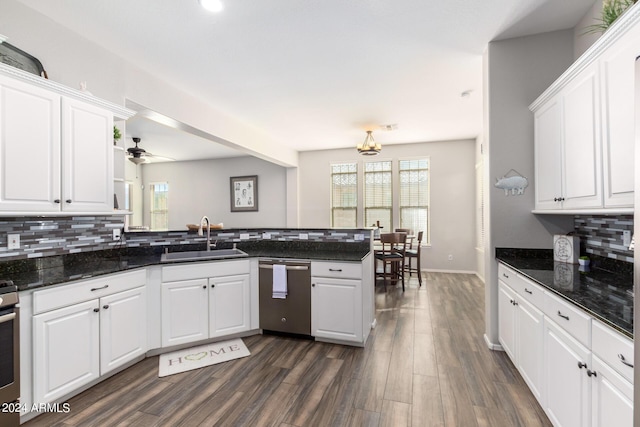 kitchen with kitchen peninsula, stainless steel appliances, white cabinets, and sink