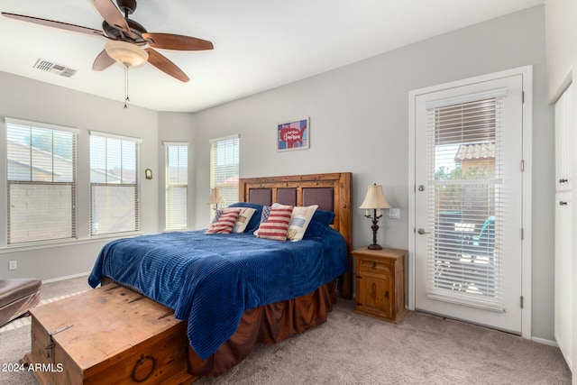 bedroom featuring access to outside, multiple windows, ceiling fan, and light carpet