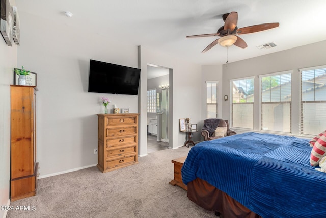 bedroom featuring ensuite bathroom, ceiling fan, and light colored carpet