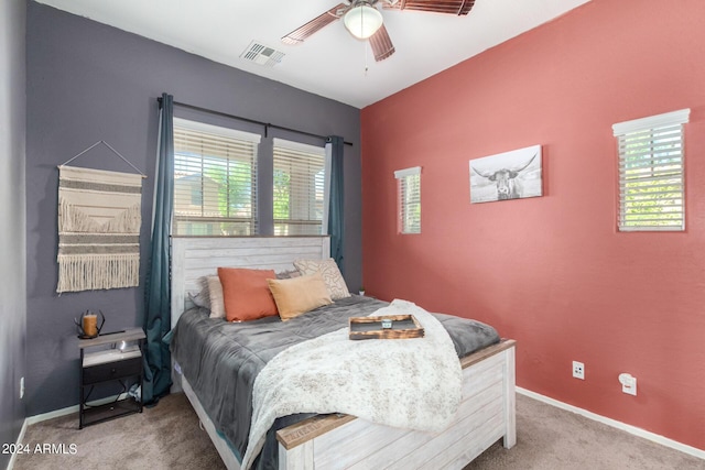 carpeted bedroom featuring ceiling fan and multiple windows