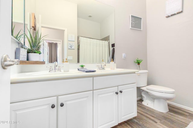 bathroom with hardwood / wood-style flooring, vanity, and toilet