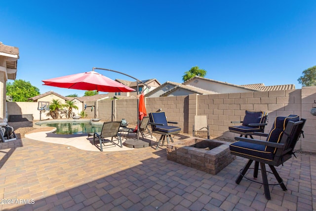 view of patio / terrace with a fenced in pool and an outdoor fire pit