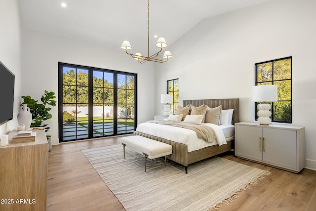 bedroom with high vaulted ceiling, a chandelier, light wood-type flooring, and access to outside