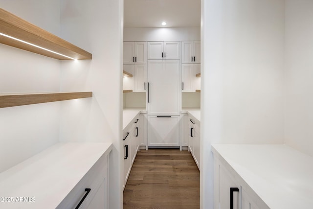 kitchen featuring white cabinetry, dark wood-type flooring, and paneled built in refrigerator