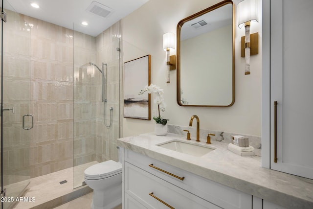 bathroom with vanity, a shower with shower door, and toilet