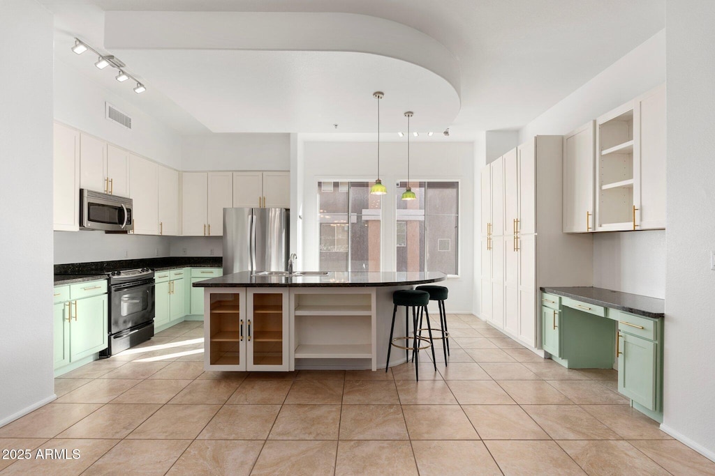 kitchen with stainless steel appliances, a center island, white cabinets, and green cabinets