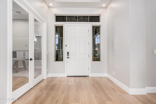 foyer with light wood-type flooring and french doors