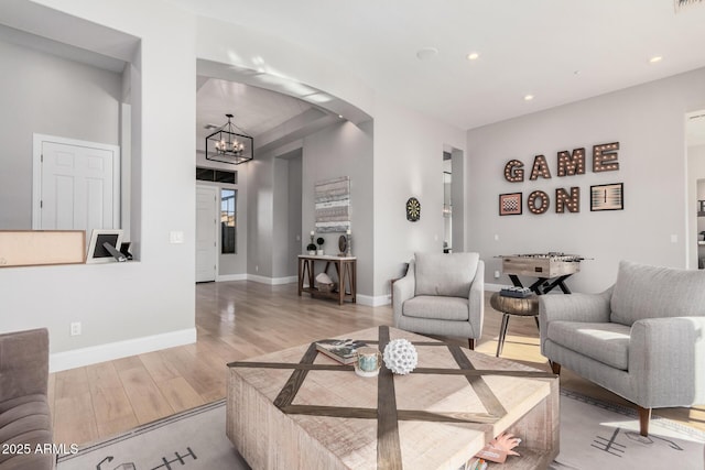 living room with an inviting chandelier and light hardwood / wood-style flooring