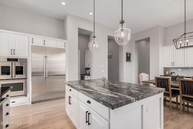 kitchen featuring a kitchen island, white cabinets, and appliances with stainless steel finishes