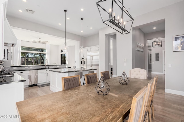 dining room with sink, ceiling fan, and light wood-type flooring