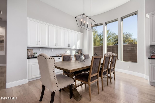 dining space with light hardwood / wood-style flooring and an inviting chandelier