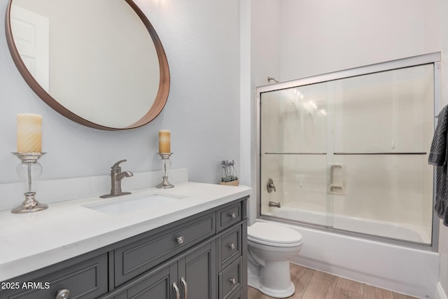 full bathroom featuring toilet, enclosed tub / shower combo, and vanity