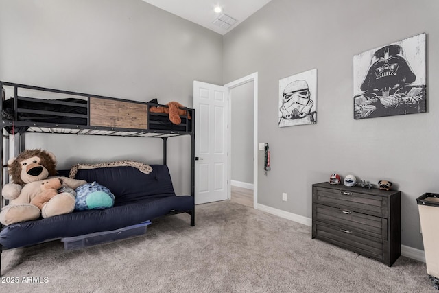 carpeted bedroom with high vaulted ceiling